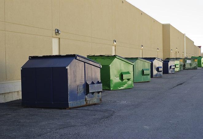 a construction worker moves construction materials near a dumpster in Canterbury